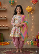 Young girl in traditional outfit with colorful dupatta standing in a decorated room with lights and gifts.